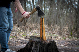 Человек с топором занимается колкой дров