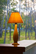 Горящая настольная лампа на фоне окна 