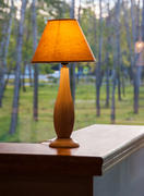 Горящая настольная лампа на фоне окна 
