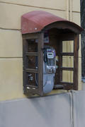 Phone booth on the wall of an apartment house in the city