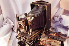 Старинный фотоаппарат и магнитофонные кассеты на ткани