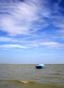 Boat floating far out to sea to the horizon