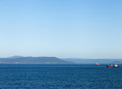 Seascape with ships and mountains on the horizon a bright sunny day