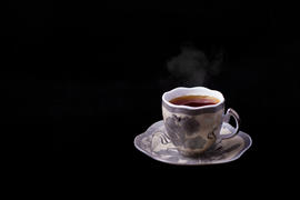Чашка горячего чая на чёрном фоне