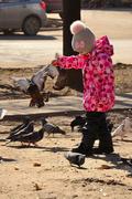 Девочка кормит птиц