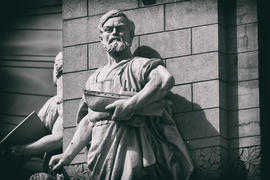 Скульптура мужчины с моделью парохода в руке