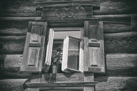 Окно с резными ставнями в деревянном доме из сруба. Россия 