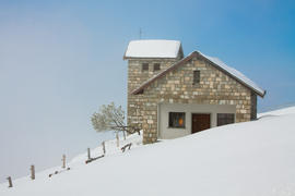 Одинокий дом в заснеженных горах в Швейцарии